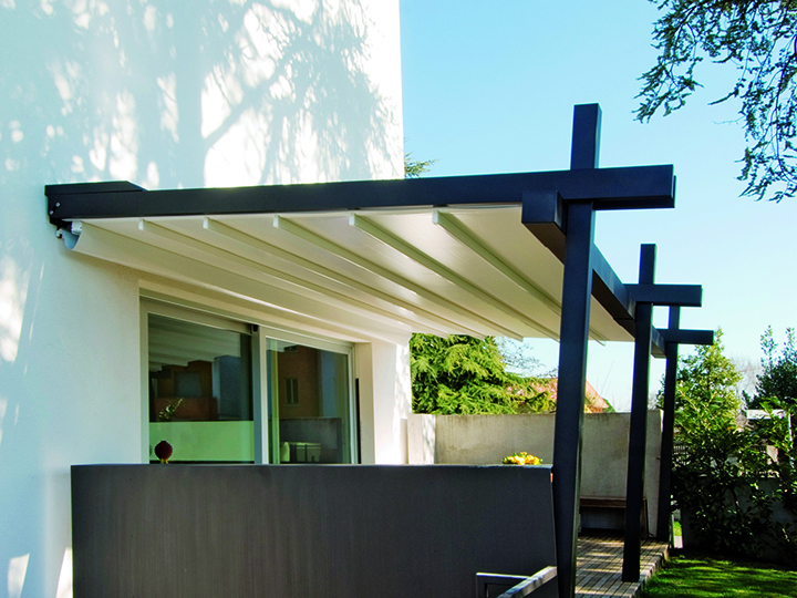 Stil Pergola Awning System - Wall Mounted black wooden pergola with cream shade extended out over small patio area